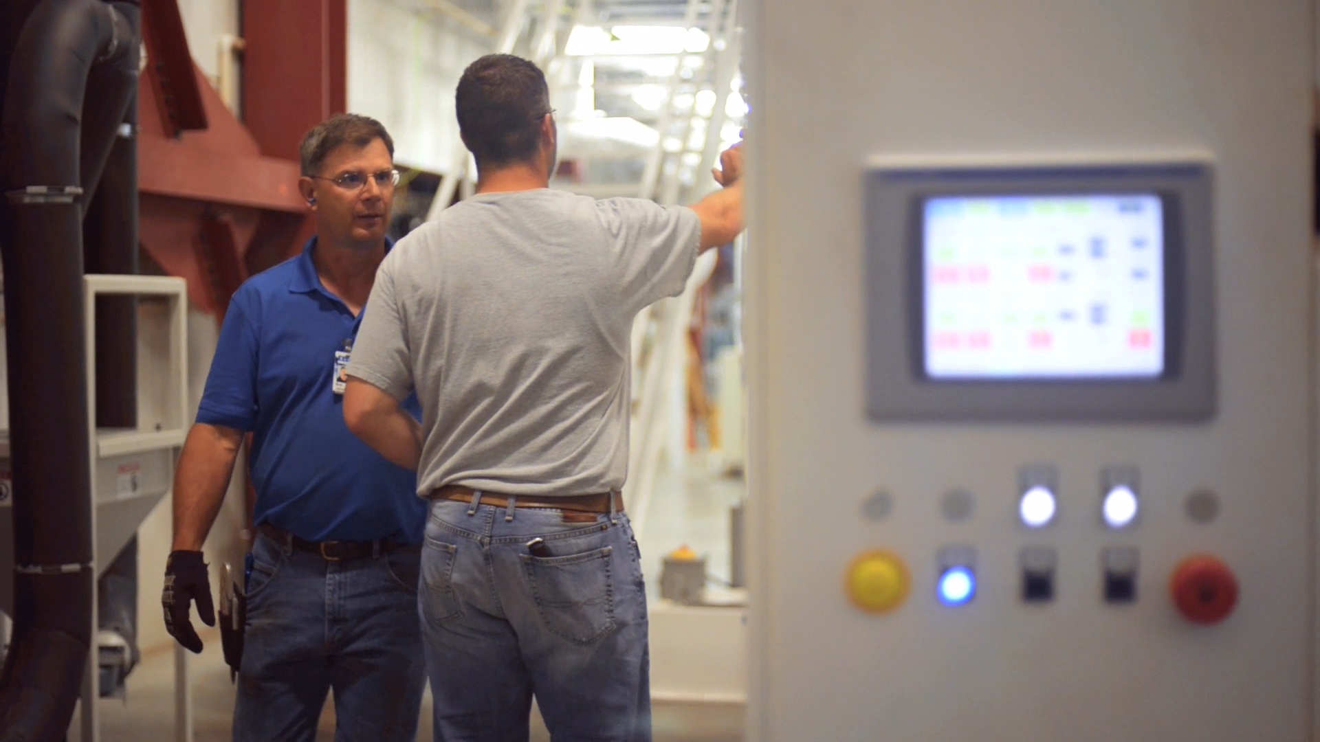 Image of two men talking in a workplace