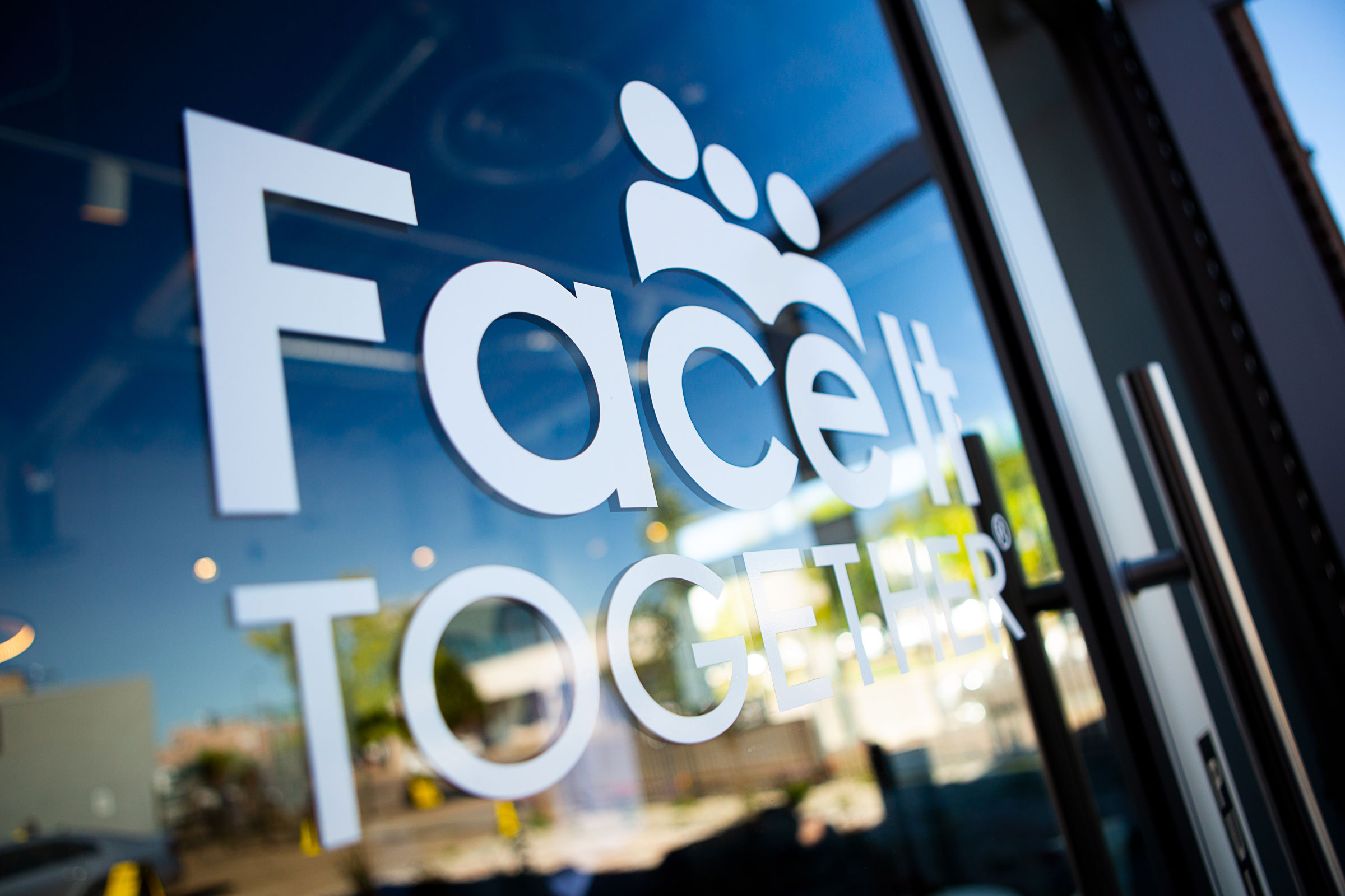Photo of Face It TOGETHER logo on window