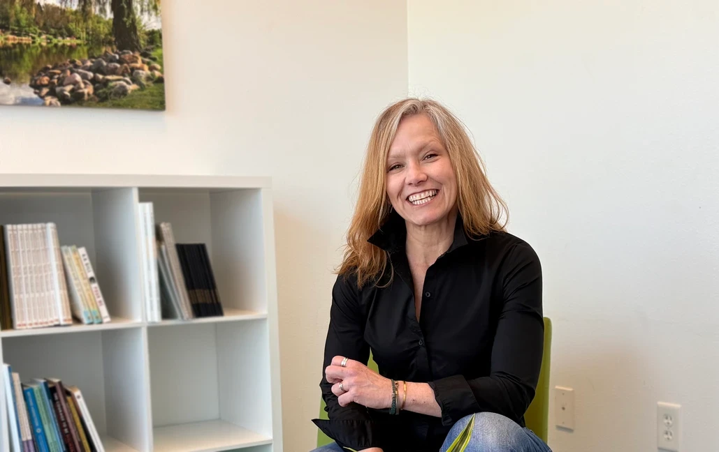 Photo of woman sitting and smiling in light room