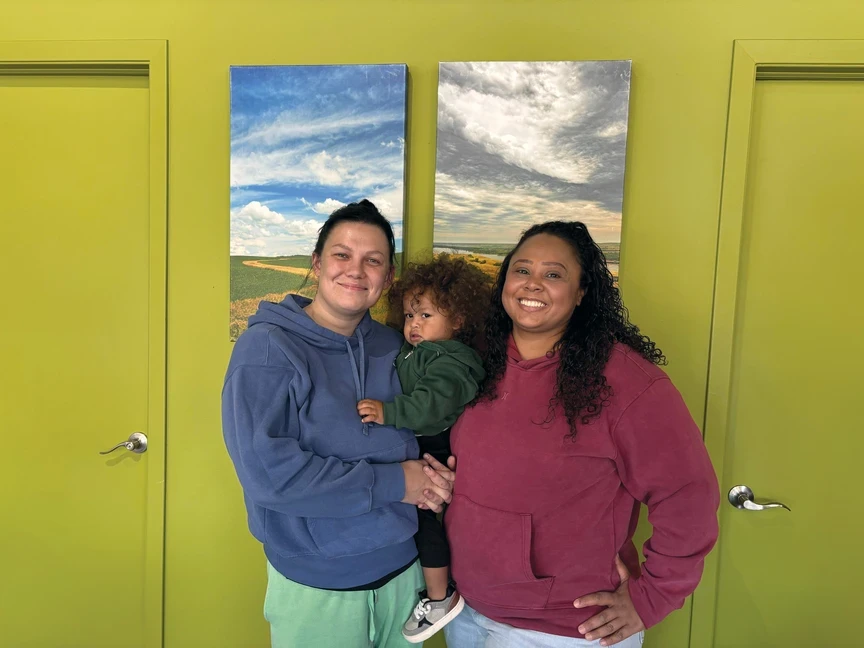 Foto de dos mujeres con un niño pequeño sonriendo
