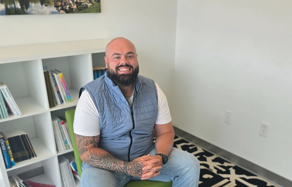Photo of man smiling and sitting in office