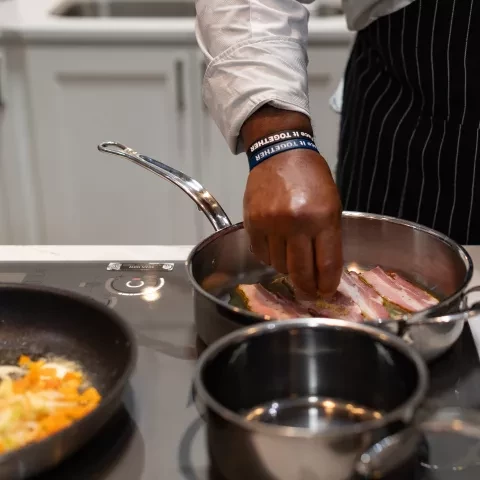 Photo of stovetop with bacon and other dishes cooking