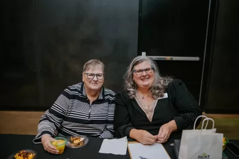 Photo of two women sitting and smiling