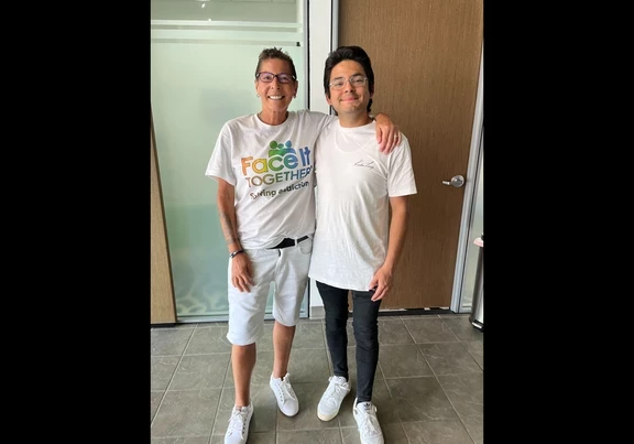 Foto de Terri y Carlos sonriendo en la oficina.