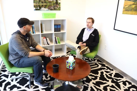 Photo of two men sitting and talking in an office