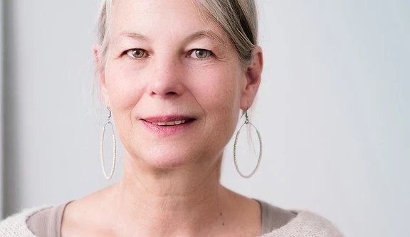 Stock photo of woman with grey and brown hair and hoop earrings 