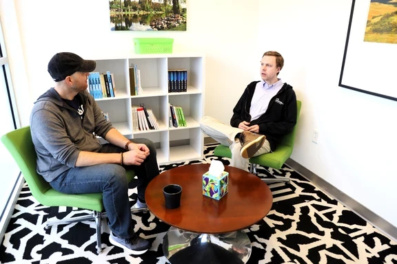 Photo of two men sitting and talking in office